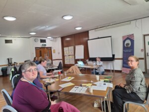 Members of the Advisory Group sitting at a desk during the Advisory GRoup Away Day