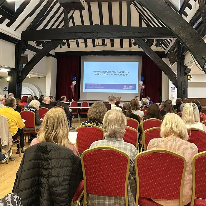 Photo from our AGM with people listening to speakers